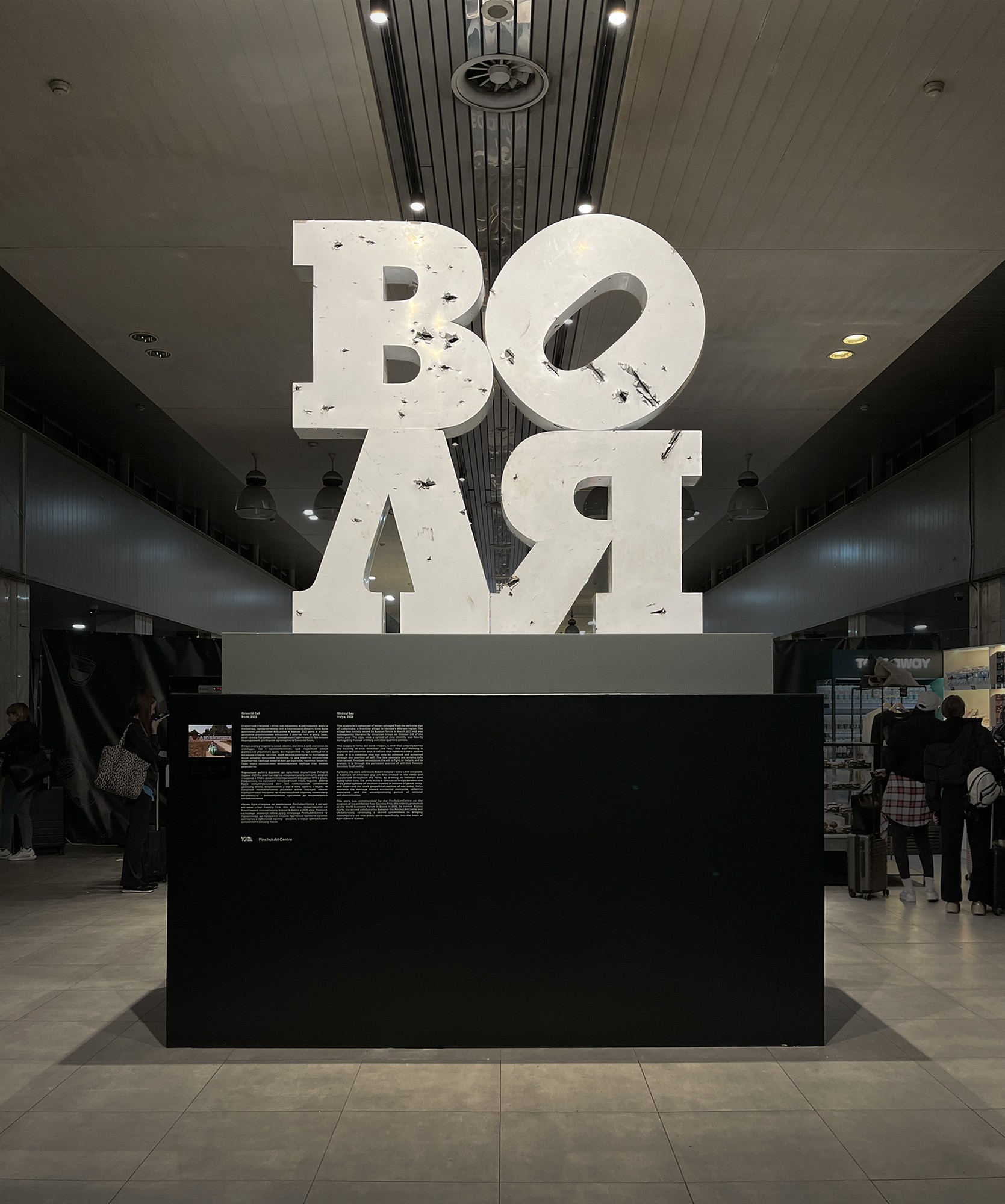 Volia. 2025, sculpture.  Plastic letters, metal, composite panels. 3 x 3.5 x 1m